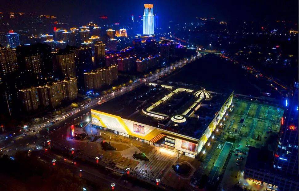 在许昌万达广场,一楼入口处设置有疫情防控工作台,工作人员用护栏隔成