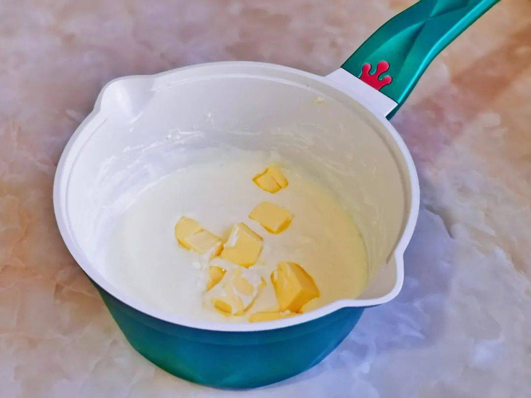 牛奶与奶酪完全融合,加入黄油继续隔水融化,搅拌至黄油与奶酪融合在