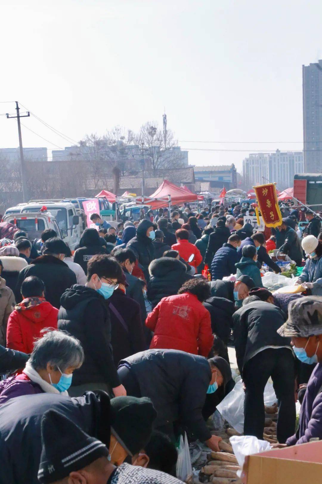 雖然過往人群和一字排開的小販大多都戴著口罩,但集市上的年味並沒有