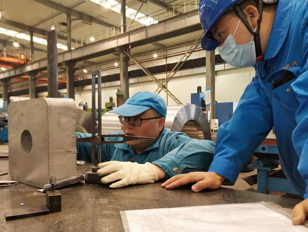 金工分厂创新工作室领军人万方前和划线钳工杜为正在为零件做加工前的