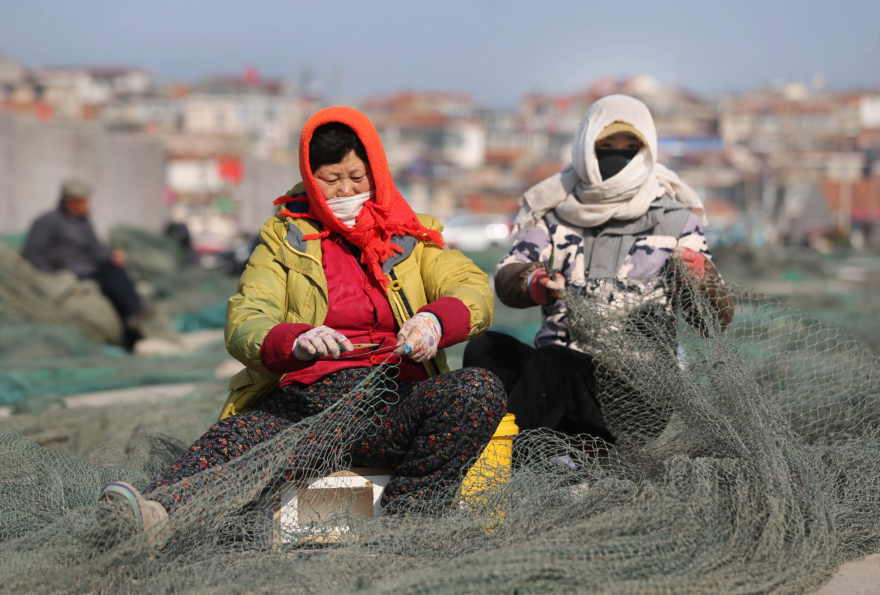 2月19日,江苏省连云港市连岛渔民在修补网具.