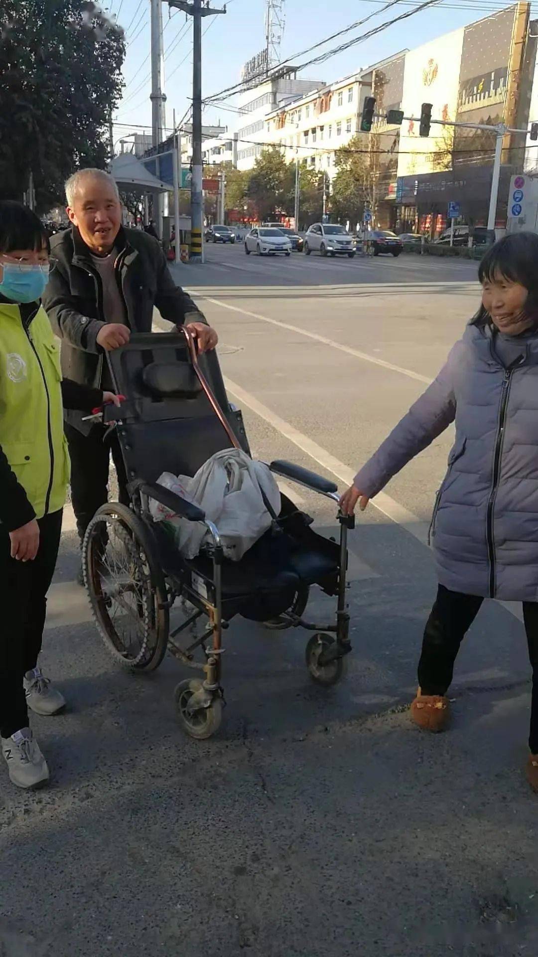 义工家人朱永利帮助残疾人过马路.