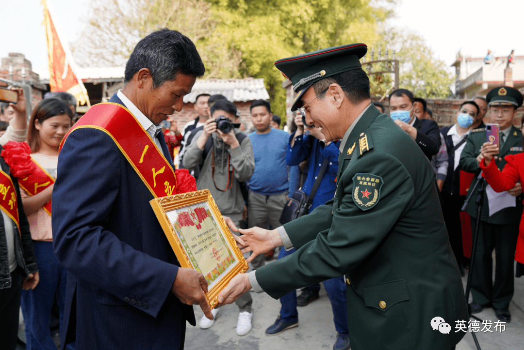 清远军分区政委邱博把立功喜报送到郭子愿父亲手中