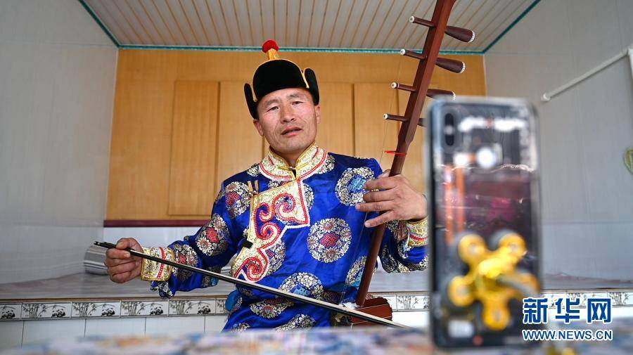 内蒙古自治区通辽市开鲁县脱贫户包莲在直播弹奏四弦胡琴(2月22日摄).