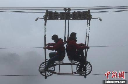 找刺激！重庆市民百米高空钢丝绳上骑自行车