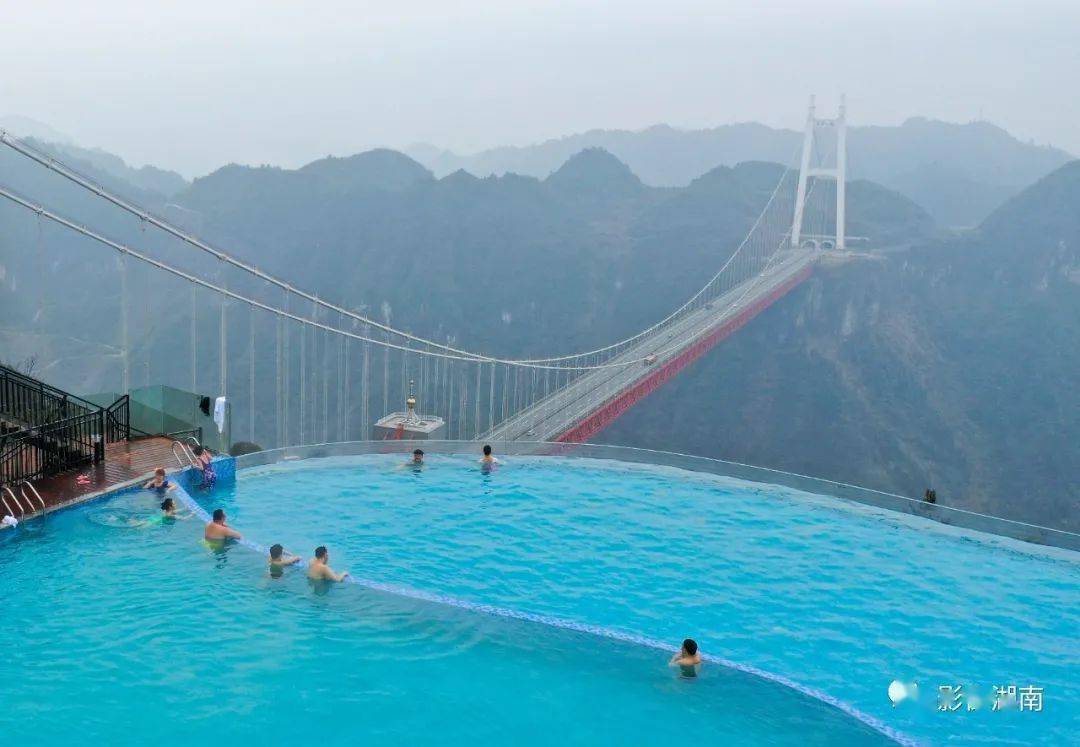 矮寨镇天桥仙居民宿客栈,游客在无边际泳池里远眺矮寨大桥美景.