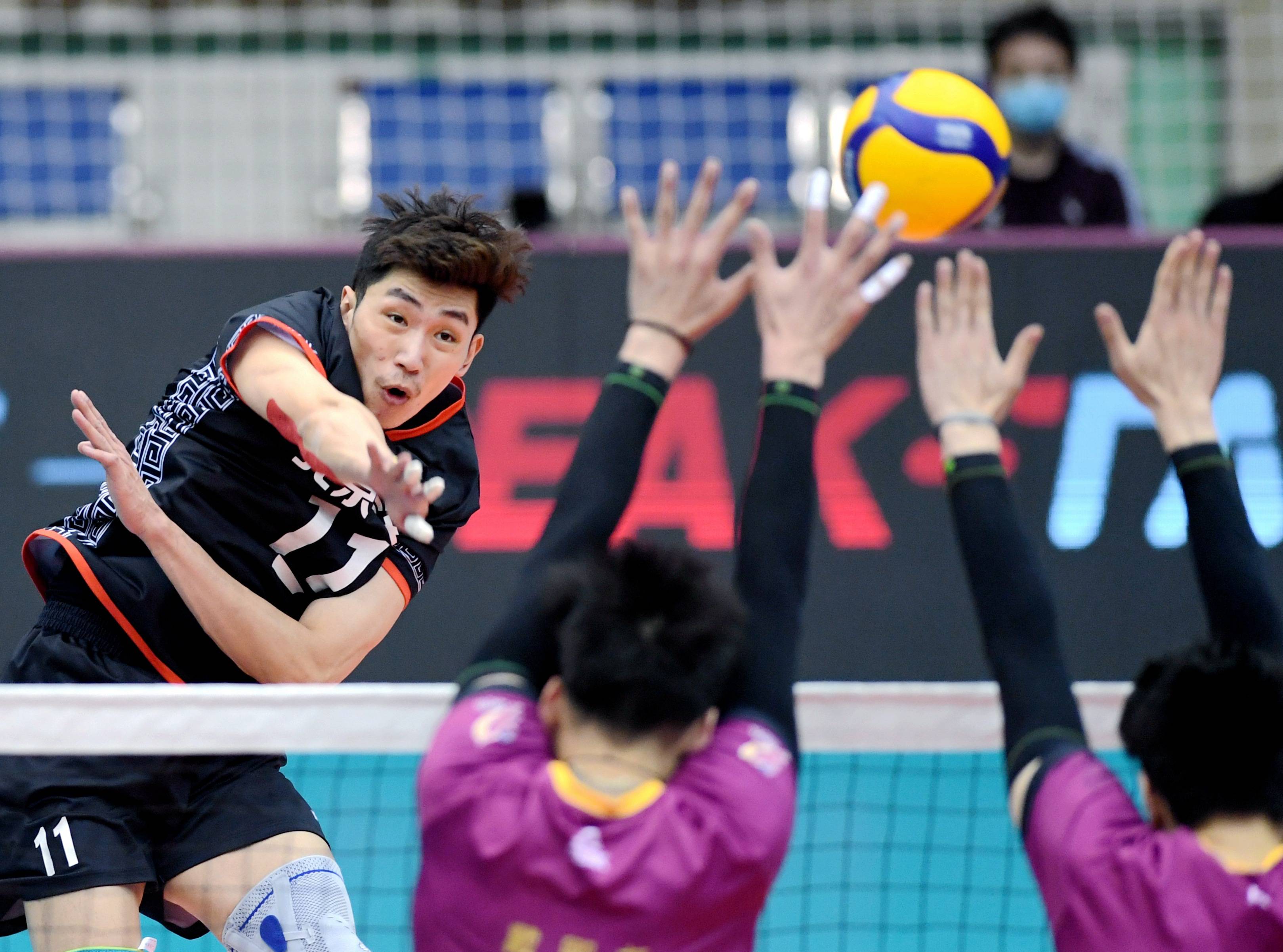 3月25日,北京汽车队球员江川(左)在比赛中扣球.