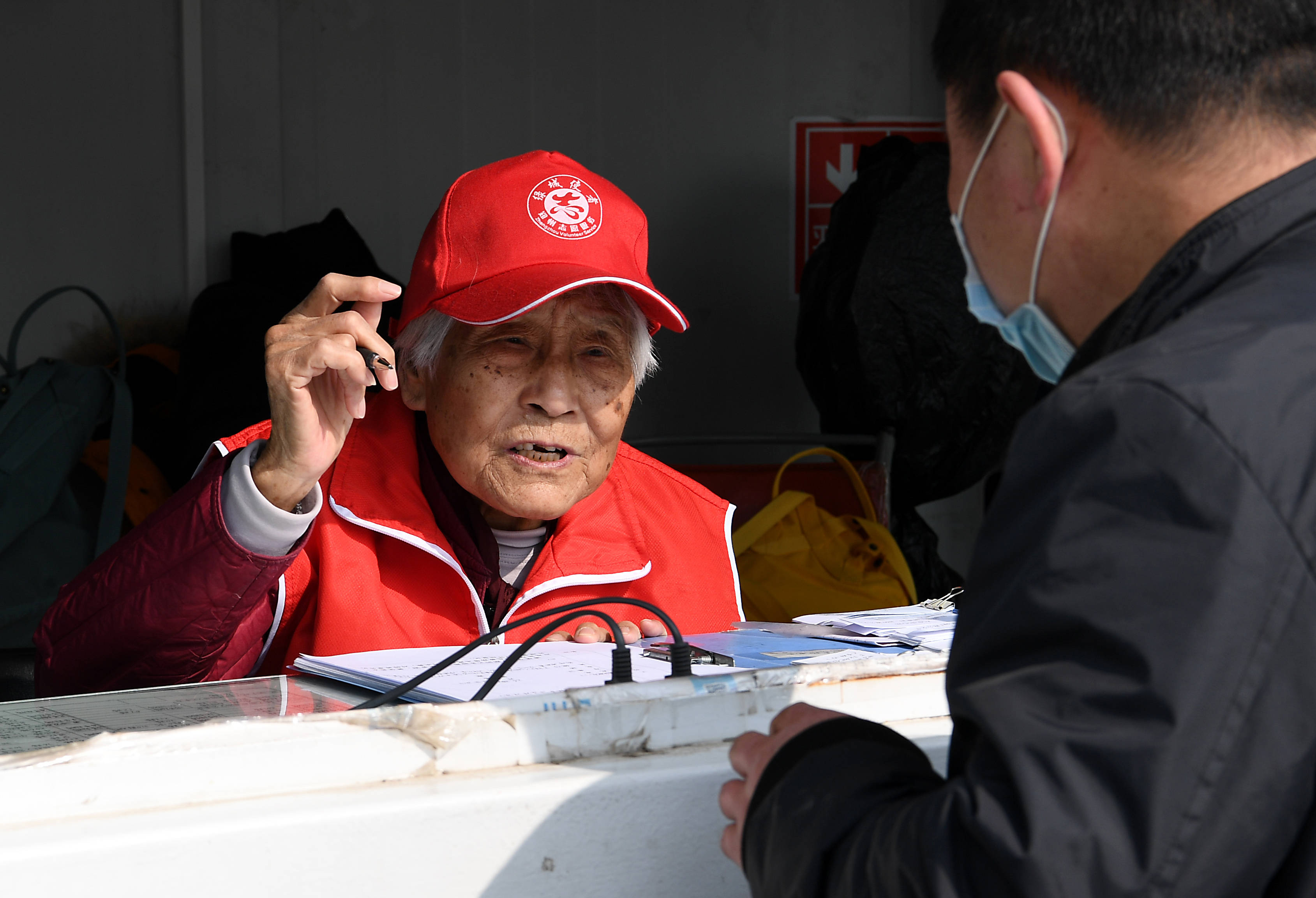 左春秀(左)在郑州火车站西广场志愿服务站里解答旅