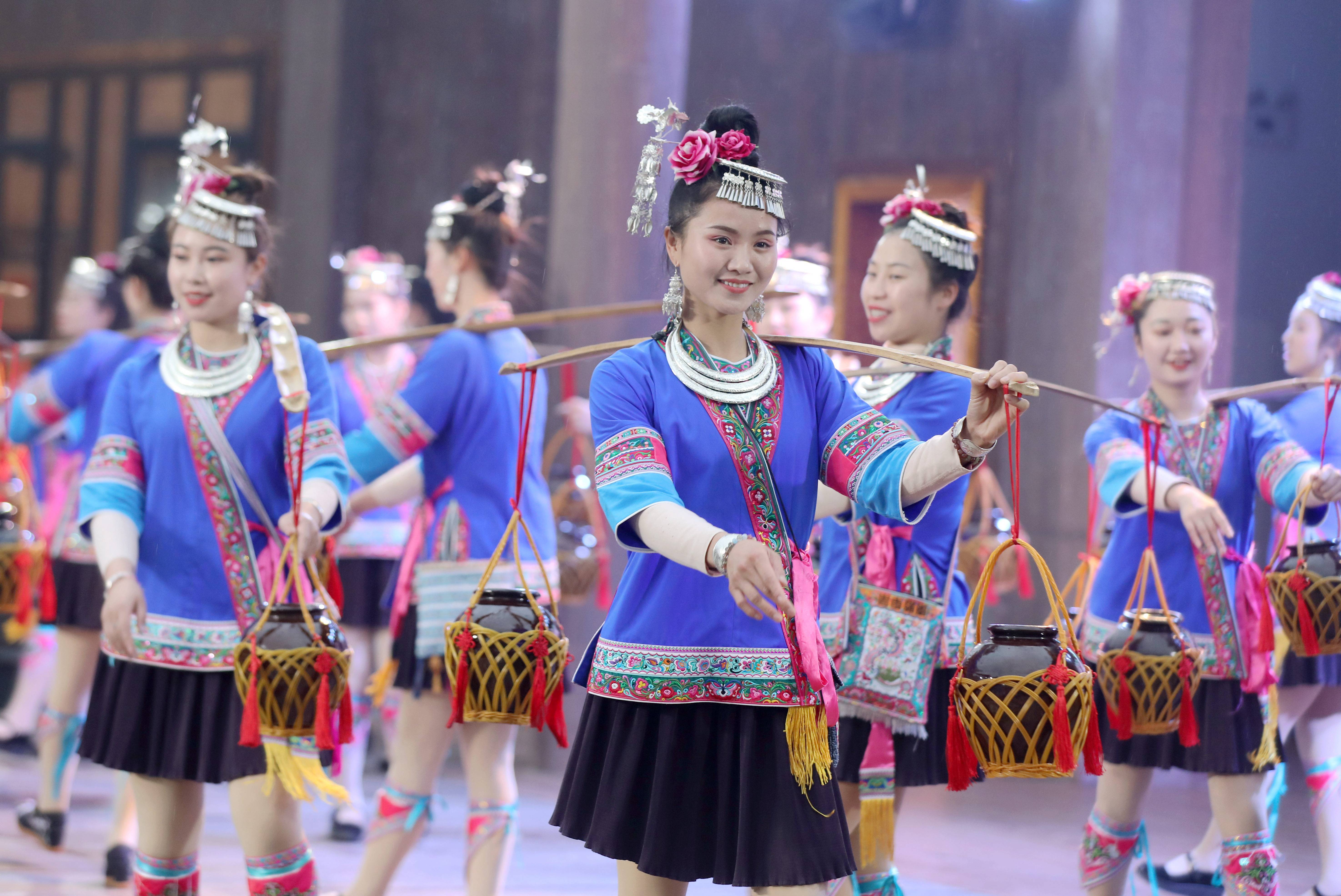演员们在三江侗族自治县月也侗寨景区挑酒参加百家宴一名学生在三江