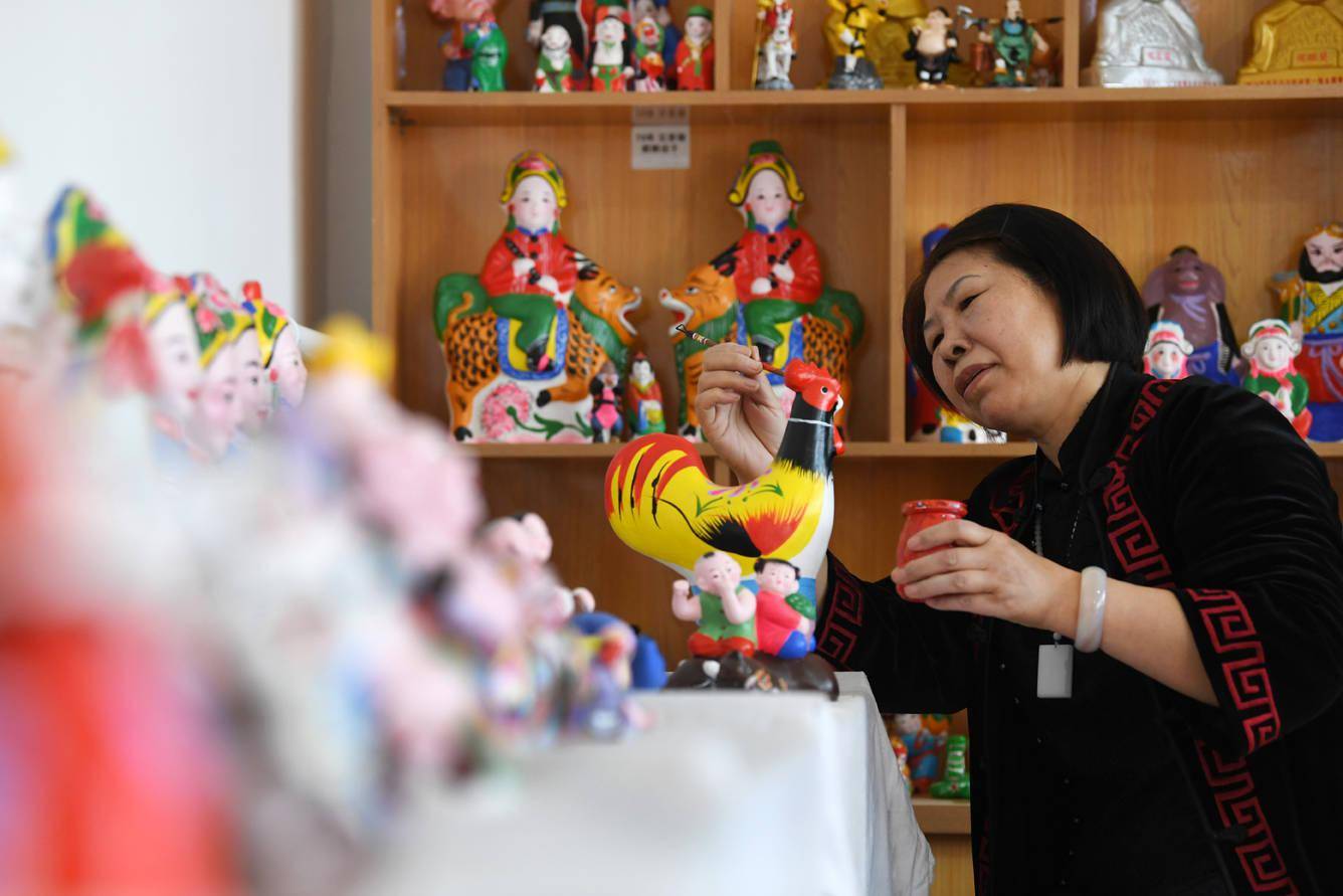 3月30日,白沟镇南刘庄村第四代泥塑传承人胡秋英正在泥塑上色.