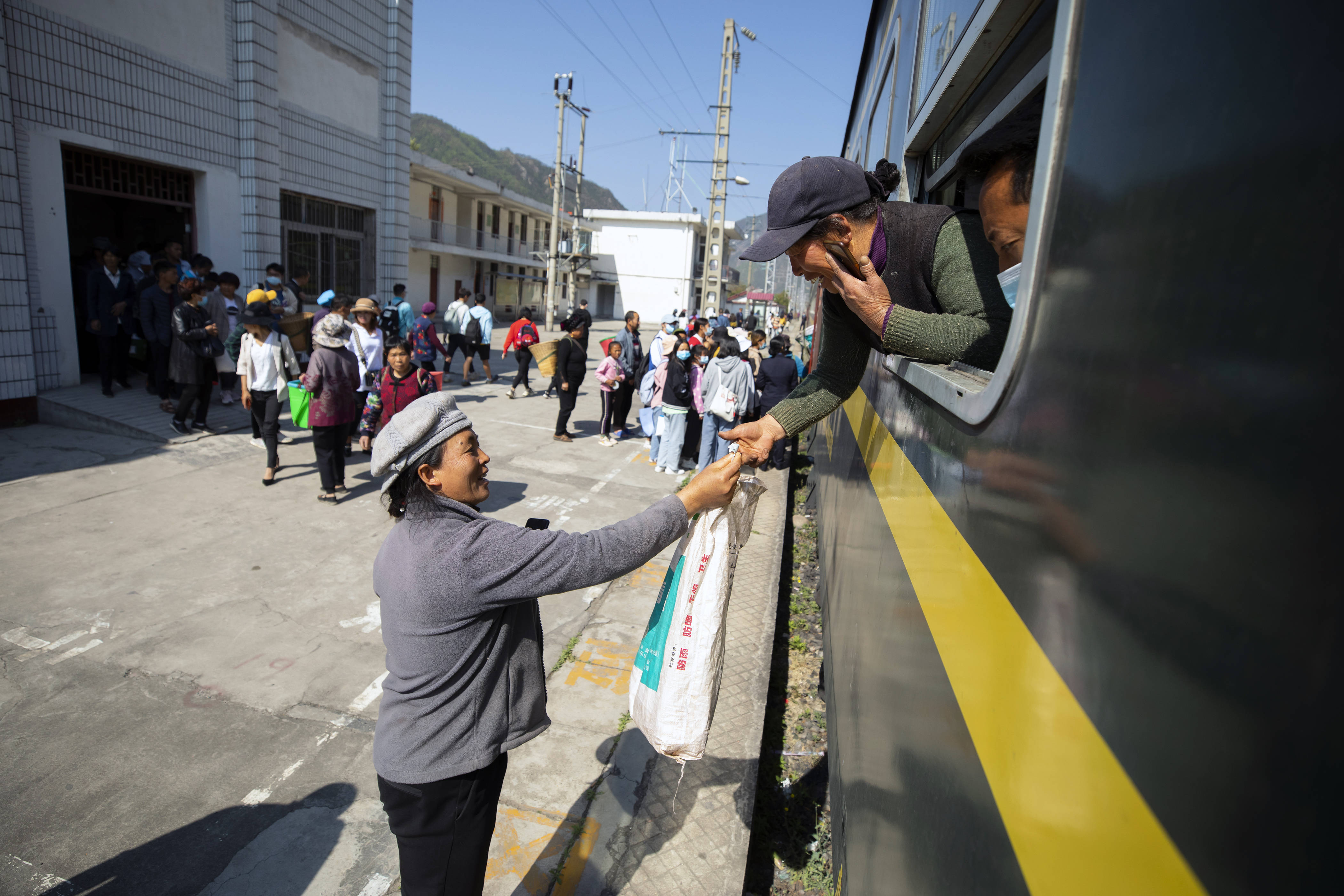 在5633次列车的行李车厢,乘客准备把他们带上车的小猪装到袋子里.