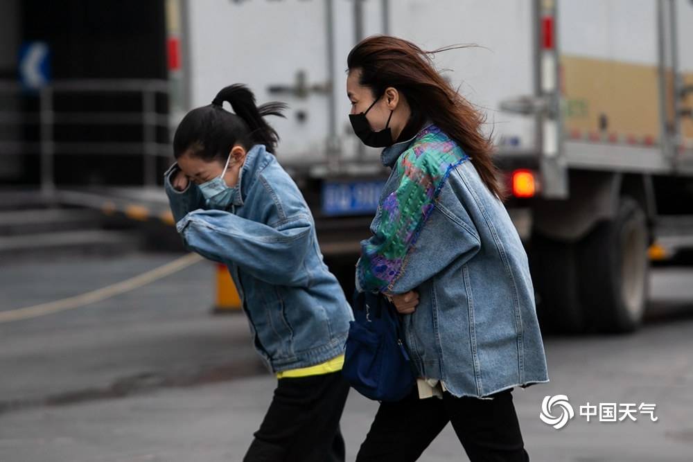 北京冷风呼呼吹街头行人厚装出行泥点车排长队