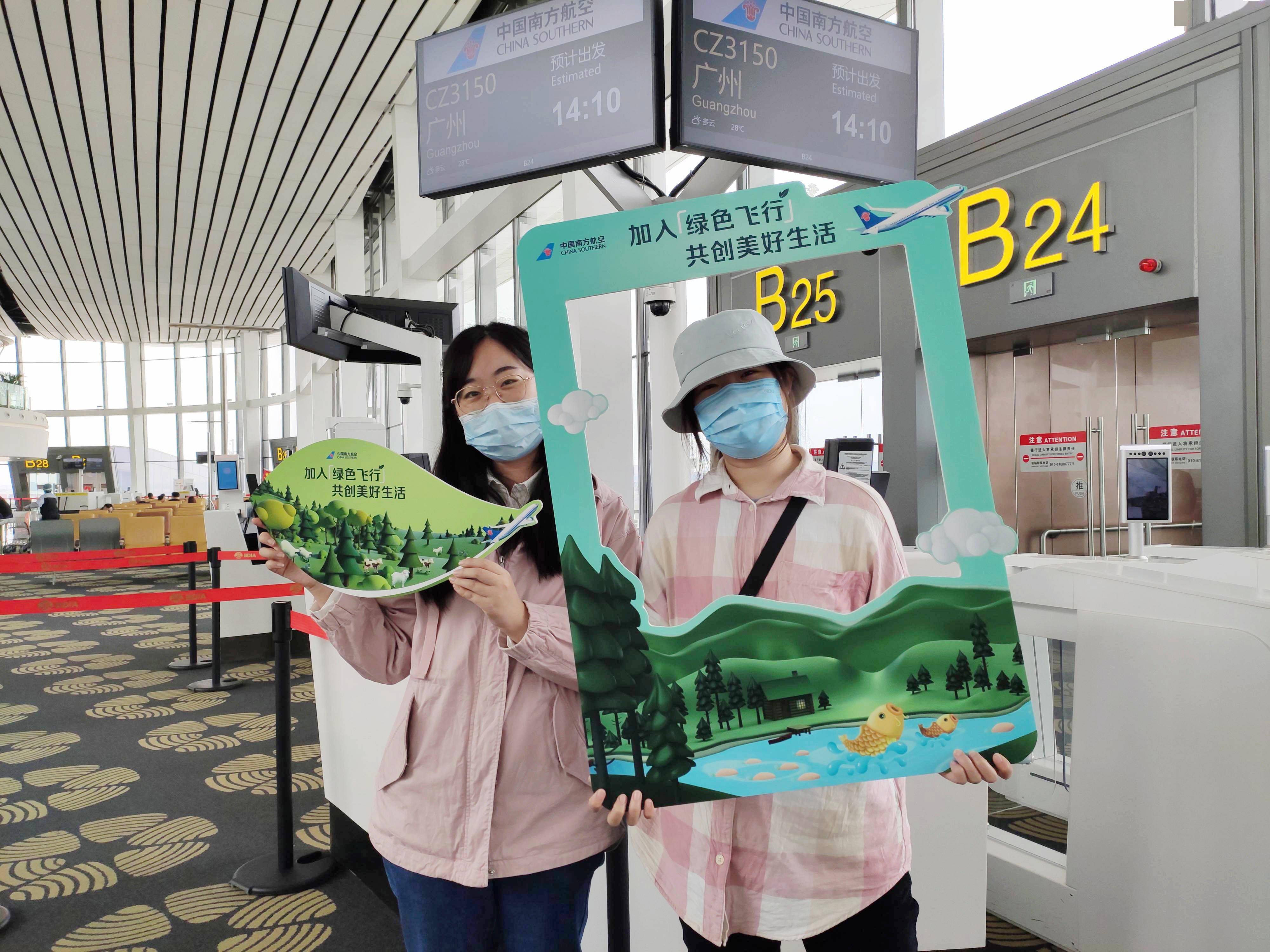 北京大兴机场以及cz3121主题航班上,旅客们通过现场工作人员的手举牌