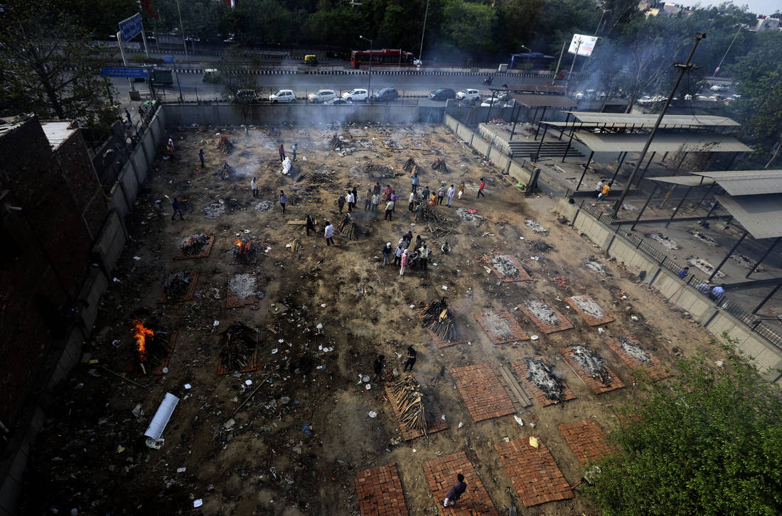 印度新德里,新冠患者的遗体在一块被改造成火葬场的空地上焚烧