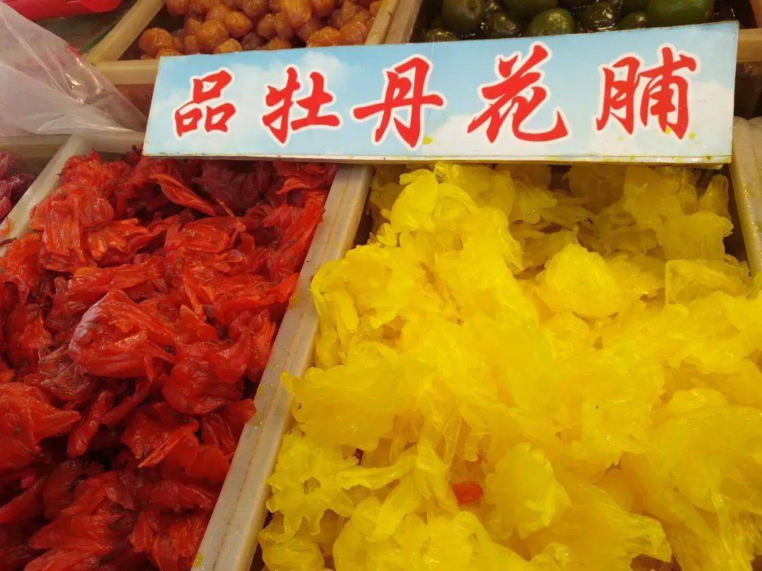 牡丹花蜜饯是用新鲜牡丹经过采摘,糖水煮制,浸泡,烘干和整理包装等