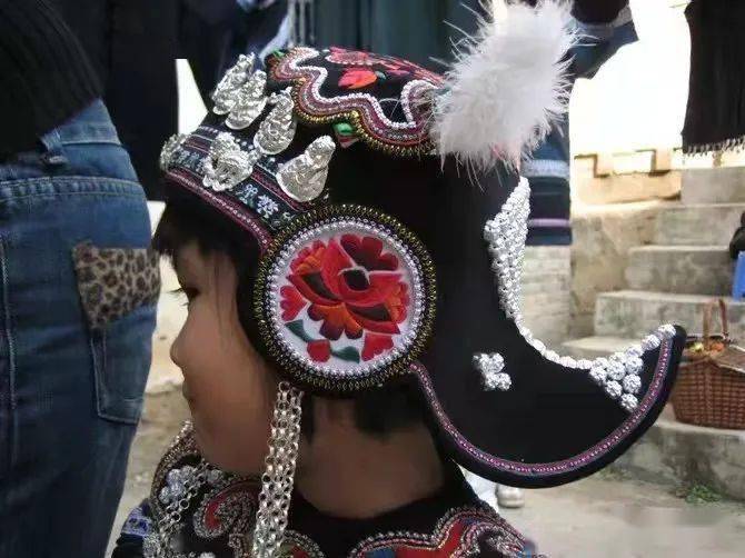 哈尼族童装的特点是简洁明快,以护身保暖为本,佩有银铃,狗牙齿,贝币等