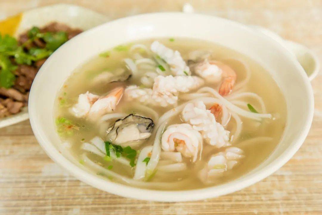 而我选择的是海鲜粿条汤,上桌那刻,看着粿条上铺盖着的丰富海鲜食材
