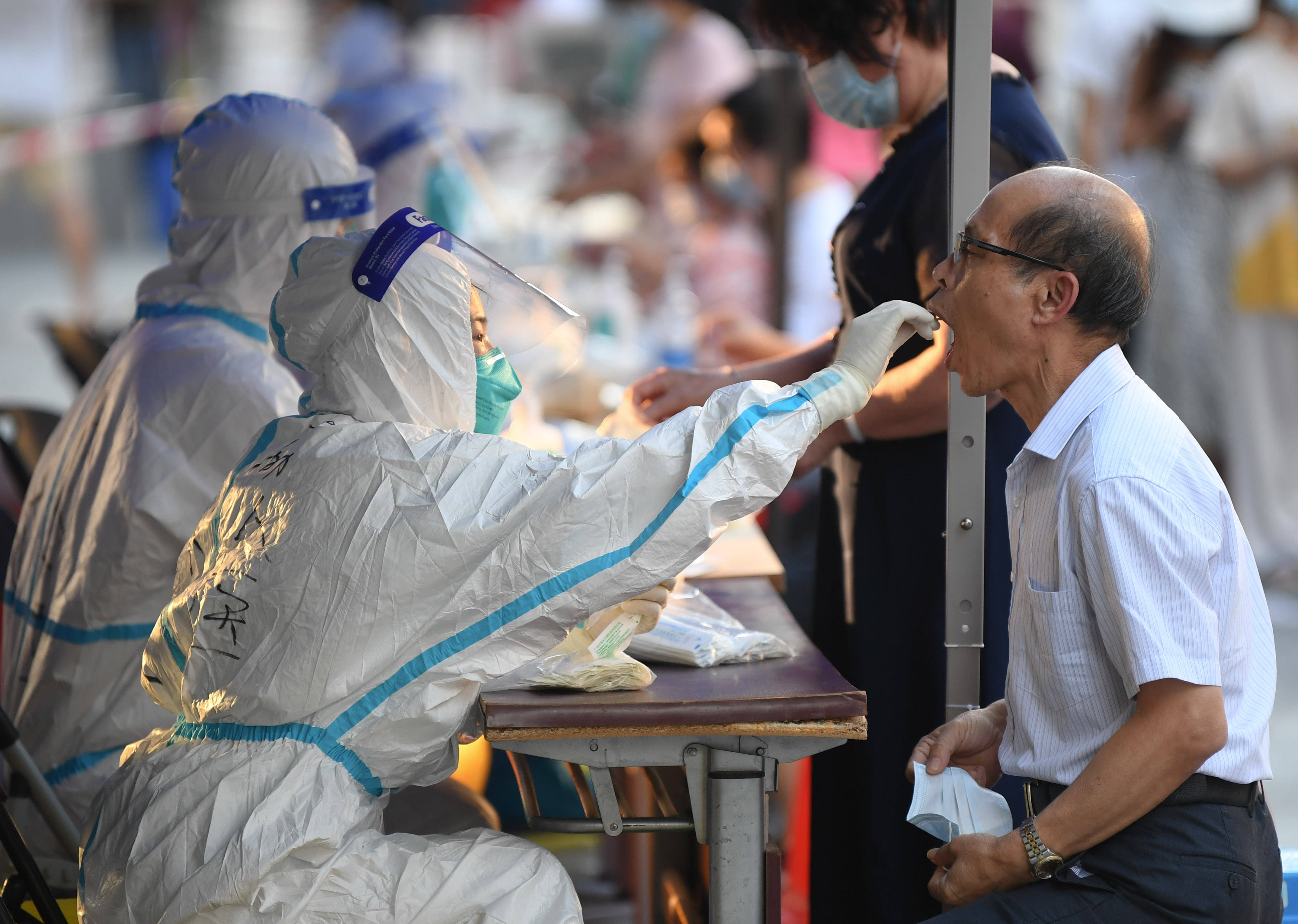 6月10日下过大雨后,在广州荔湾区白鹤洞街广钢新城,一位社区防疫志愿