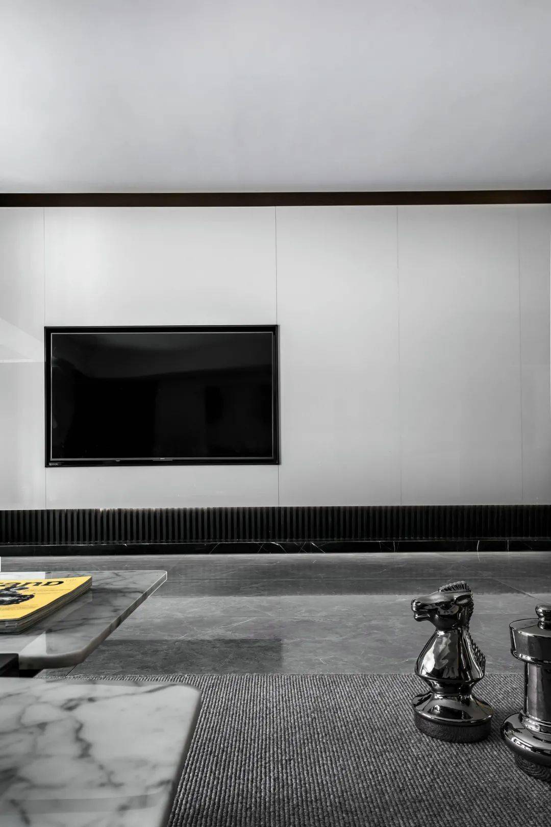 客厅在灰色地面砖的空间下,电视墙以极简的设计,地面装上黑色的地台