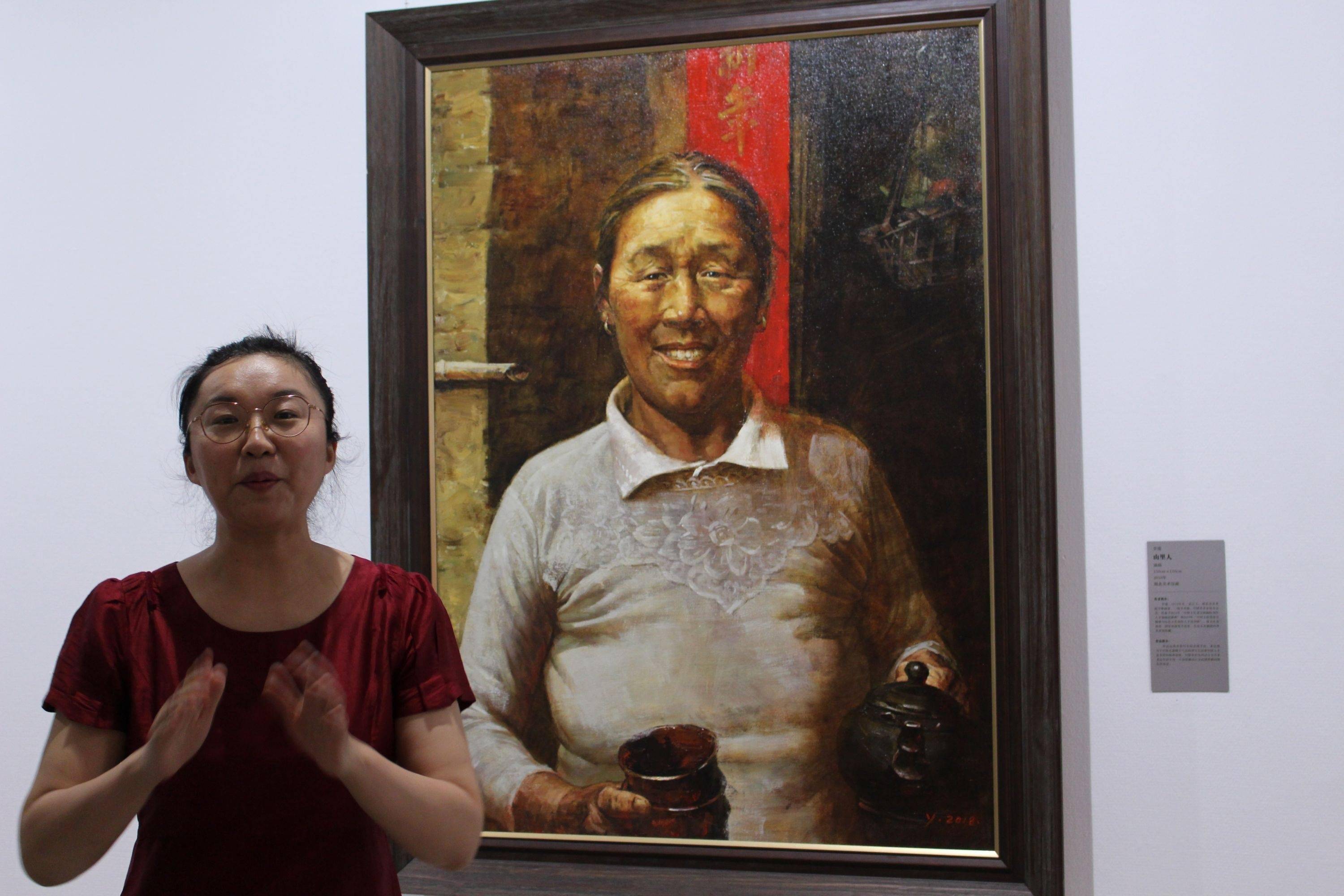 青年画家李瑾在自己创作的油画作品《山里人》前接受采访.