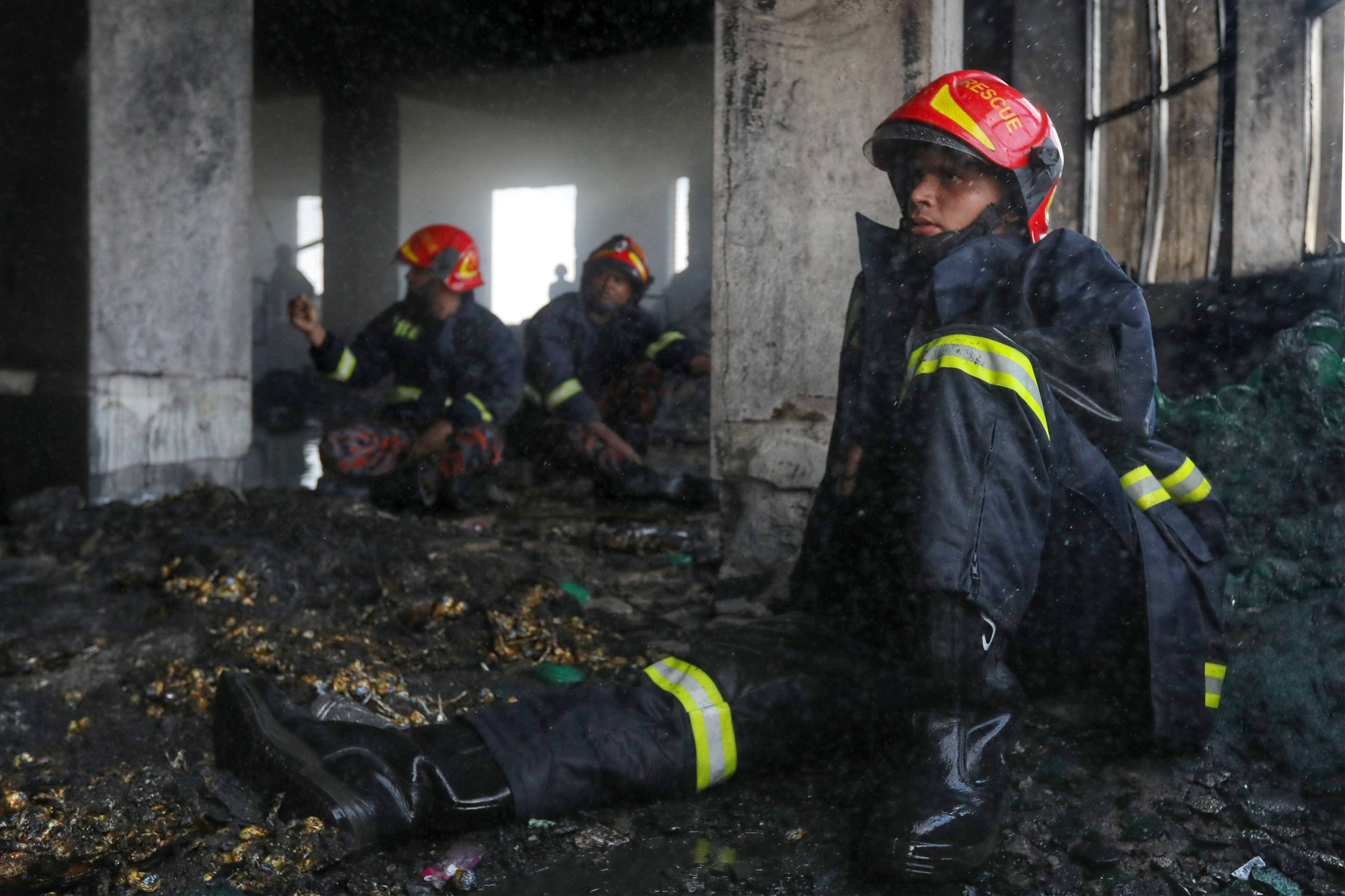 7月9日,消防人员在孟加拉国纳拉扬甘杰的工厂火灾现场工作时暂歇