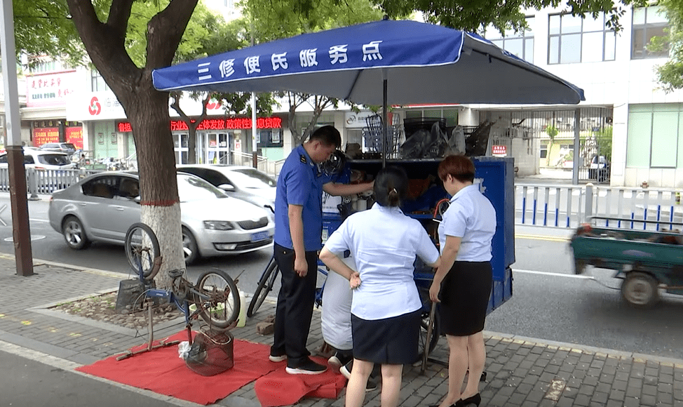 为便民服务点安装太阳伞正在和爱心企业志愿者一起临淄区综合行政执法