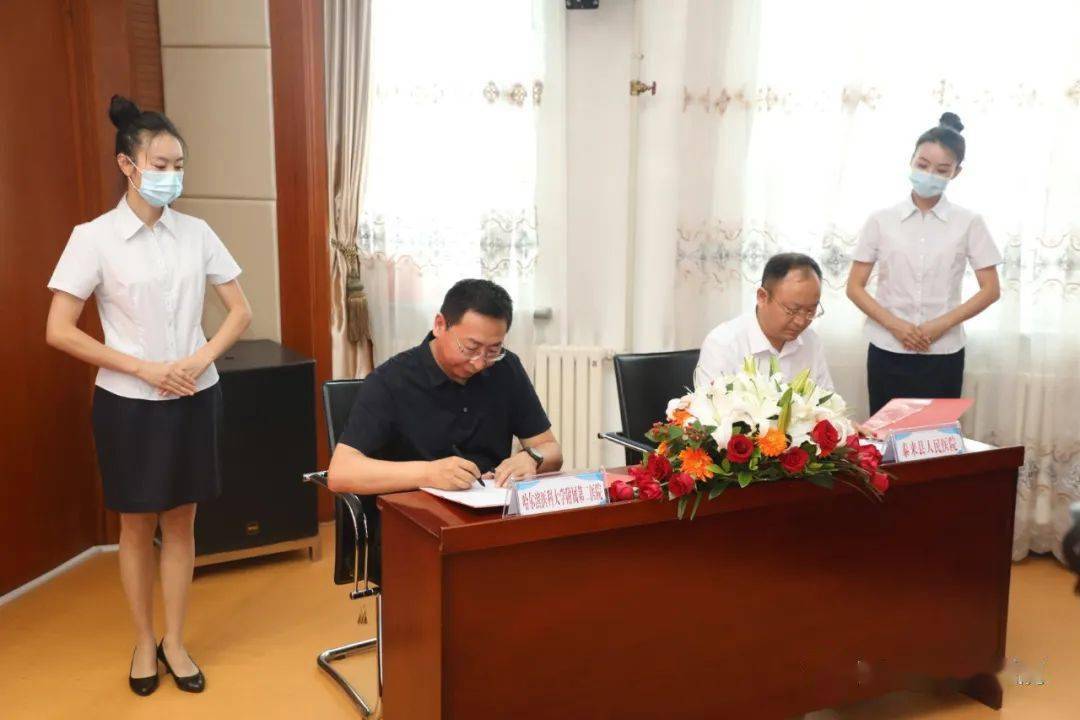 图为:哈医大二院副院长付然与泰来县人民医院院长殷长青签署建立协作