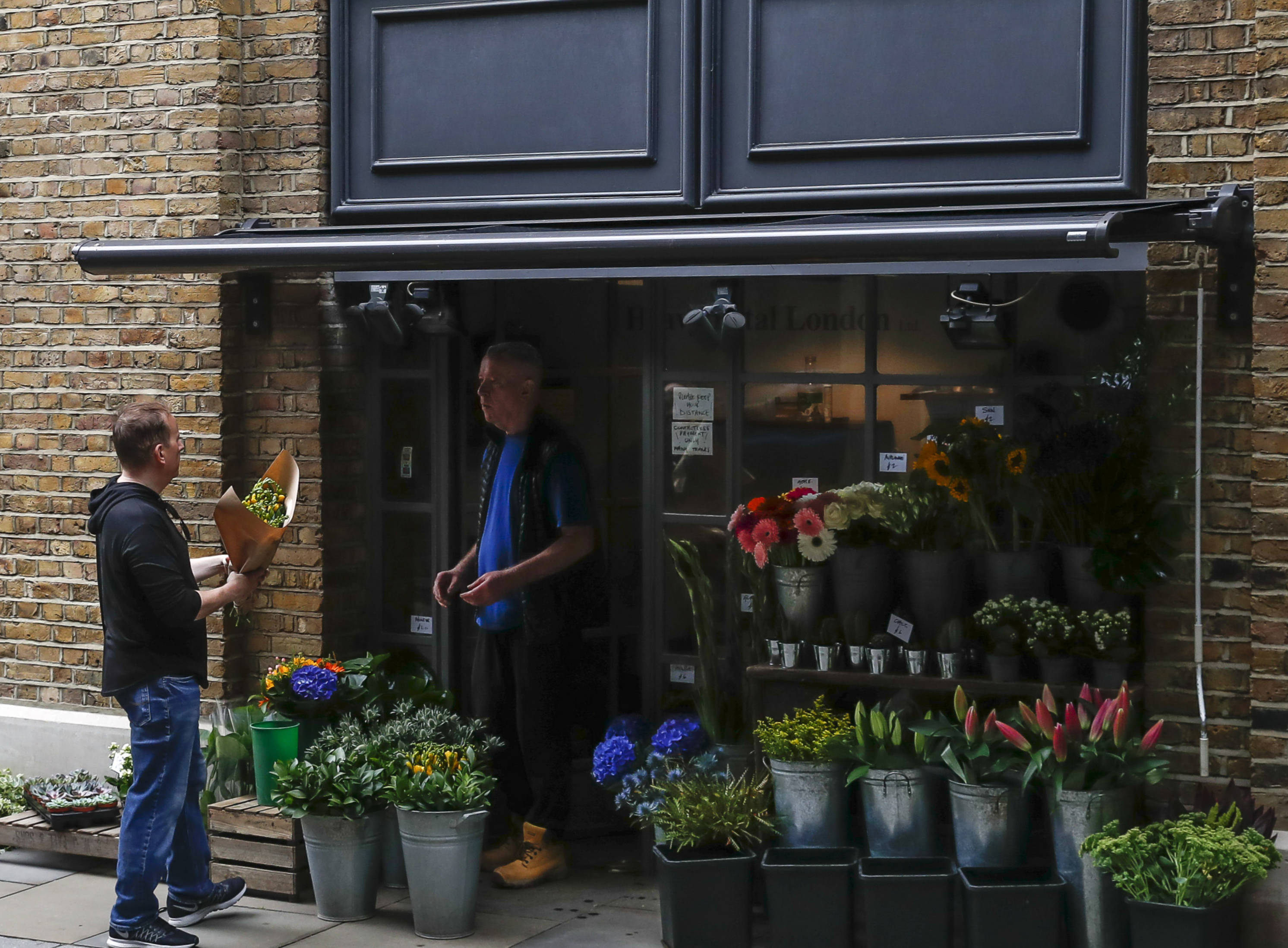 8月13日,一名男子在英国伦敦的一家花店买花.