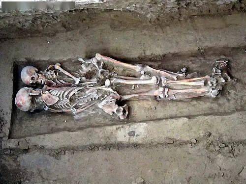 墓中两具尸骨头挨着头,脸对着脸,整个躯体缠绕在一起,两臂做搂抱状