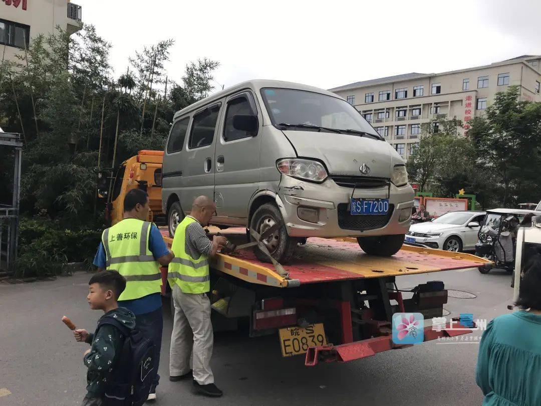 在市区锦谯佳苑小区东门,长期占用公共停车位的两辆面包车被交警用