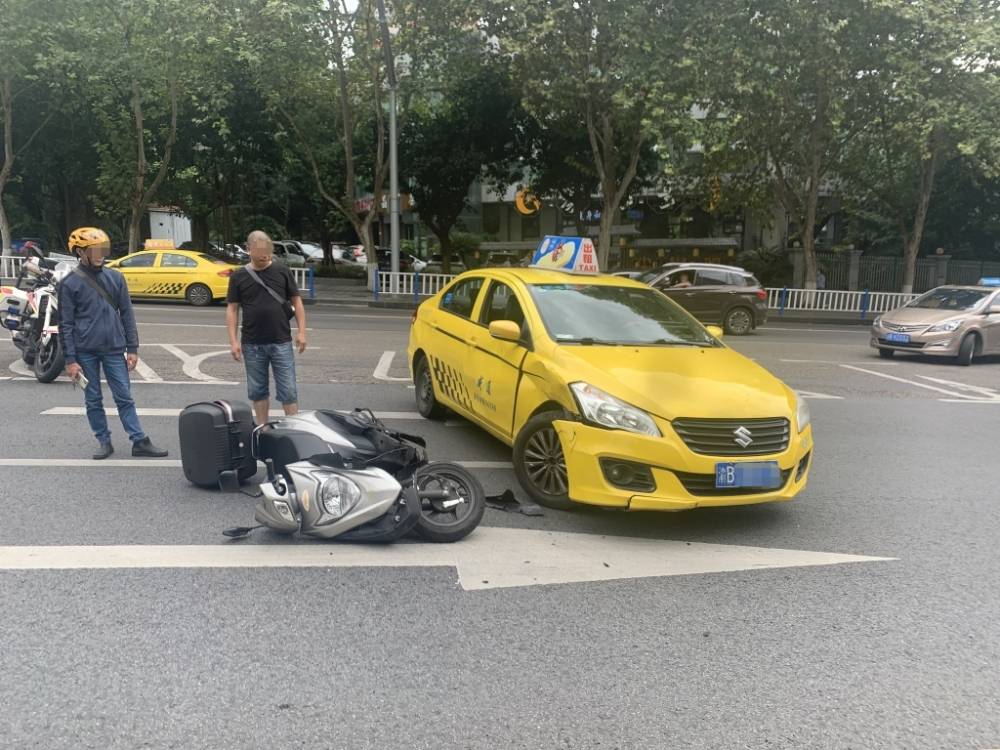 外卖小哥边骑摩托边抢单 结果撞上了出租车