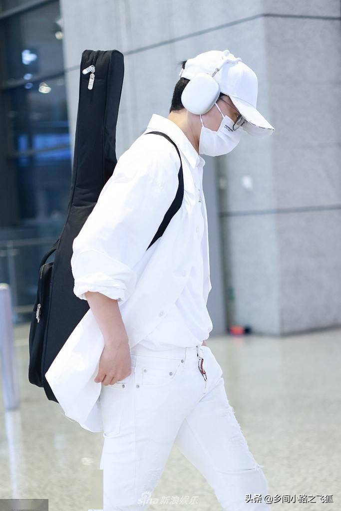 张杰白色look似王子 戴大号耳机背吉他显文艺范_上海机场