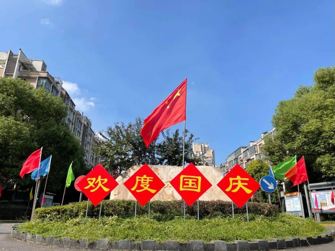 成为最美的风景线在蓝天白云,绿树红花的映衬下迎风飘扬的五星红旗在