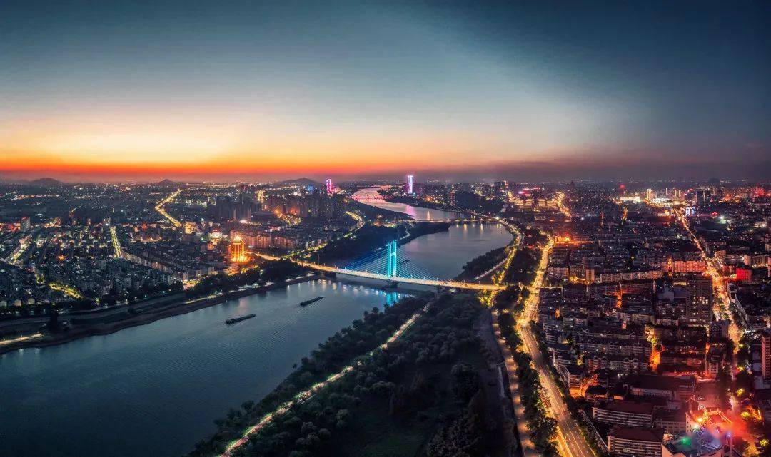 华灯初上,曹娥江水面犹如一面镜子照映出岸边的繁华.