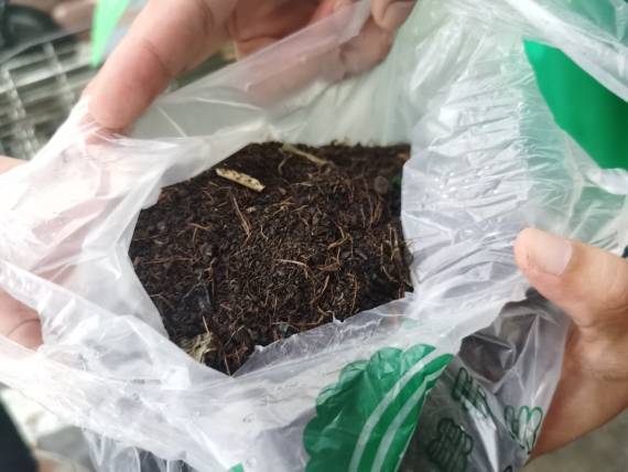 美天迎宾菜市场负责人吴光兴小心翼翼地打开一小袋刚刚打包好的营养土