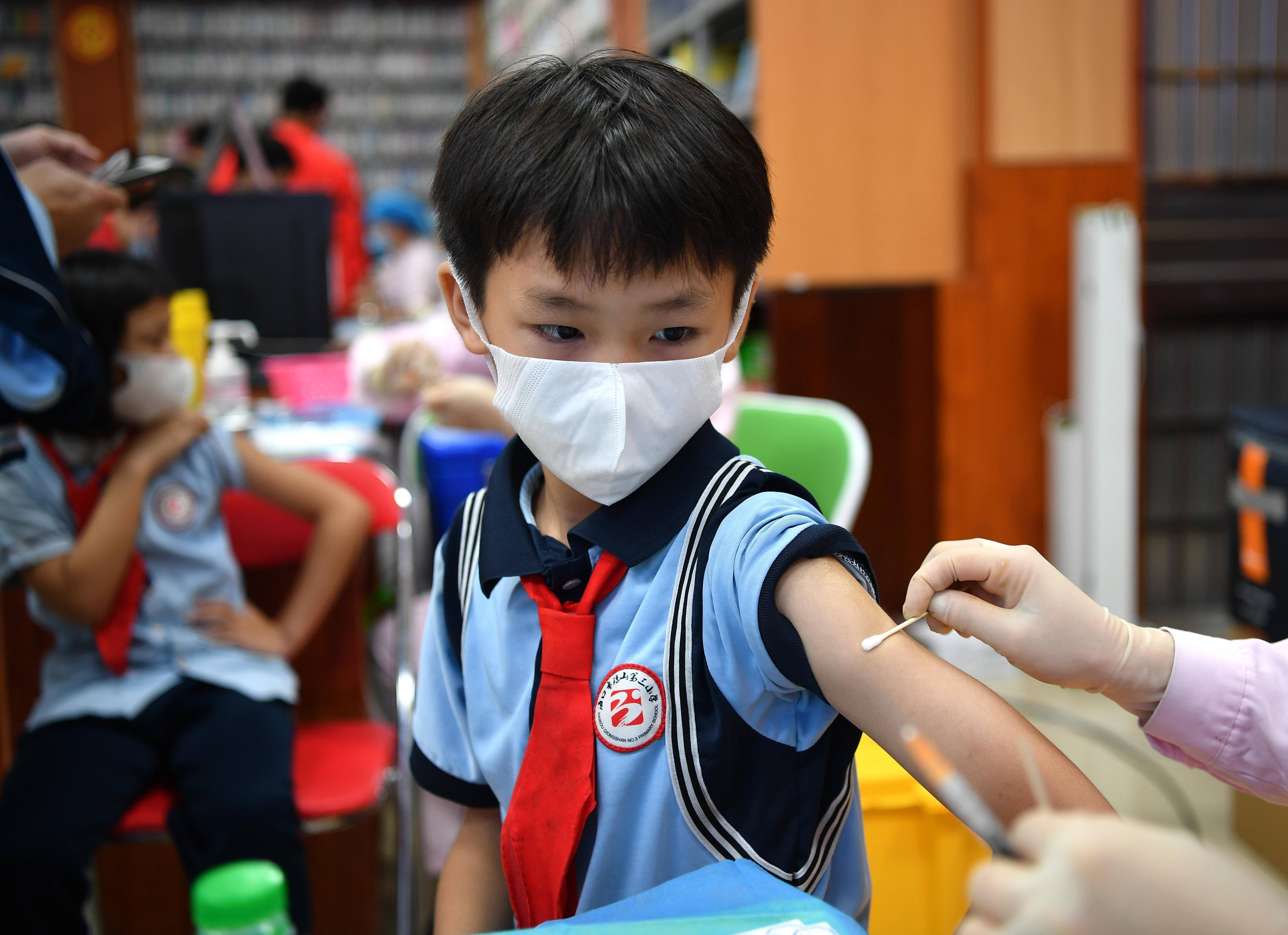 10月28日,海口市琼山第三小学的学生观看同学接种疫苗.