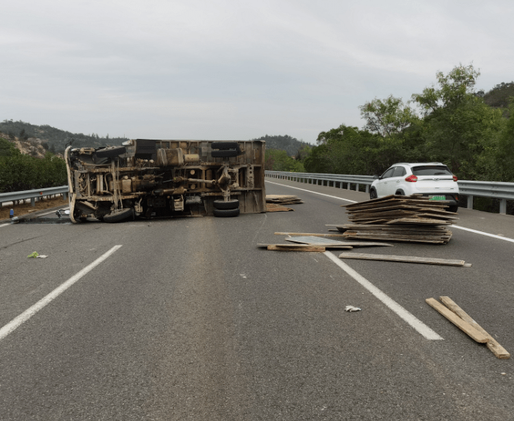惊险运送木板前往惠安高速上货车翻车木材撒落一地