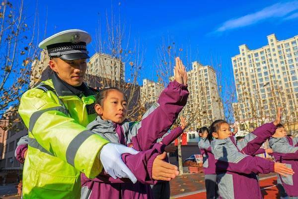 交警指导小学生学习交通指挥手势(央广网发 张永新 摄)