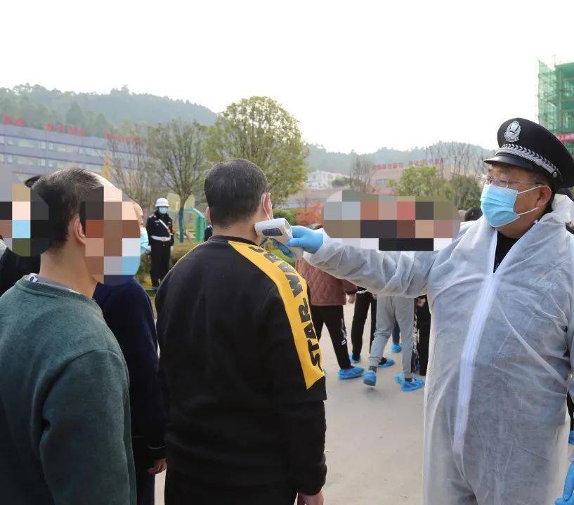 监狱民警着防护服对新收押犯进行第二次体温检测,分