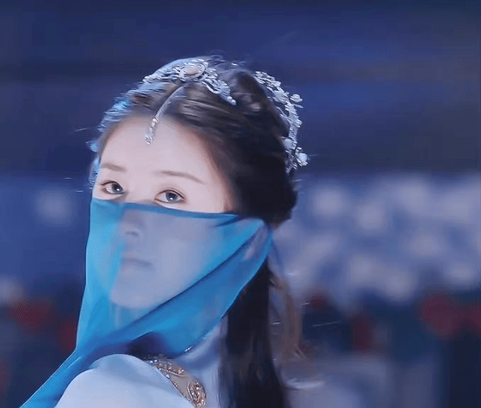 剧中,覃川冒充的舞女, 一袭蓝衣异域风情满满,妩媚至极,挽弓搭箭那