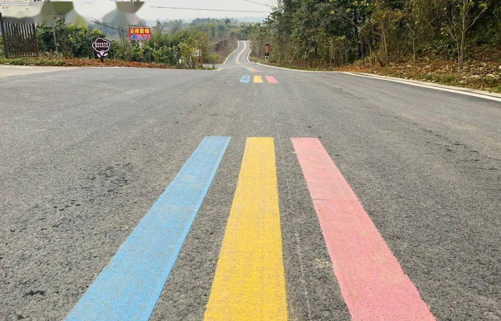 走进景区内,一条粉,黄,蓝三种颜色组成的彩虹标线,顺着车道向远方
