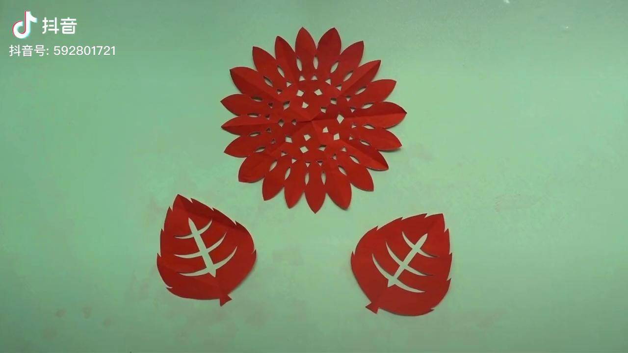 向日葵剪纸,花瓣均匀排列在圆形花盘周围,搭配叶子更有一番韵味