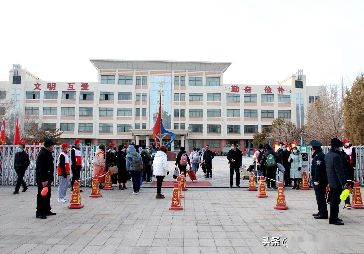 在金塔县中学的校门口设置消毒,测温点,对进入校园的学生及其所携带的