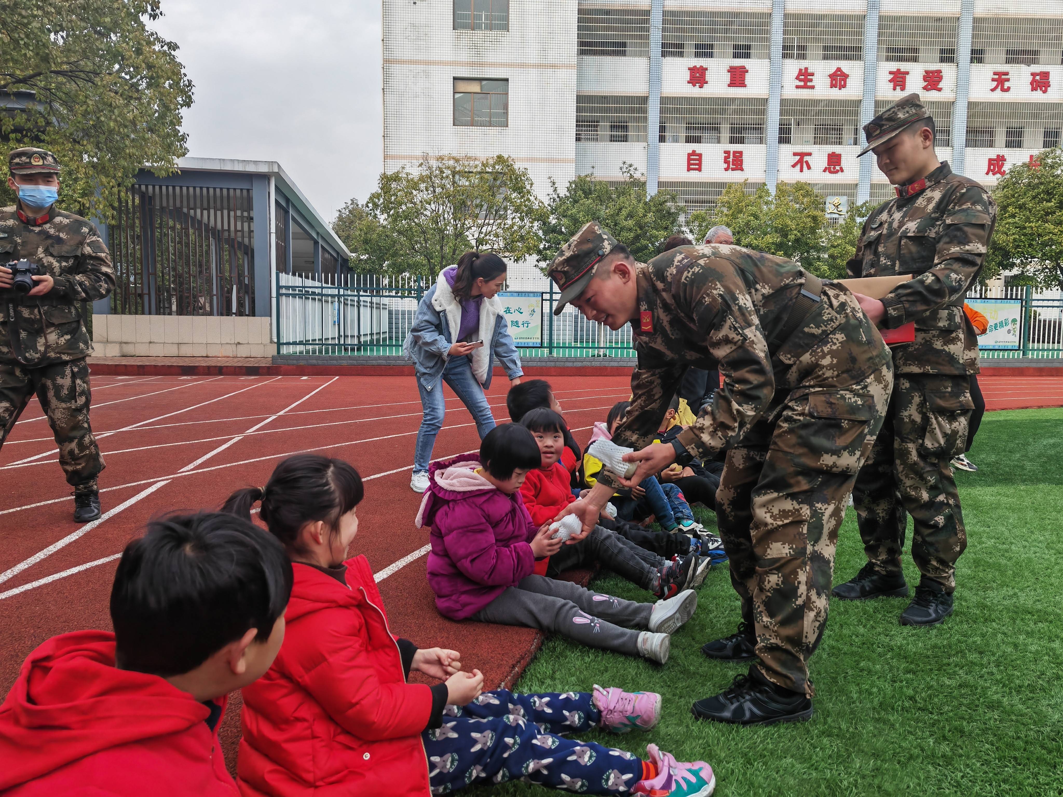 李娜)3月2日下午,市特殊教育学校足球场上,前来看望同学们的武警益阳