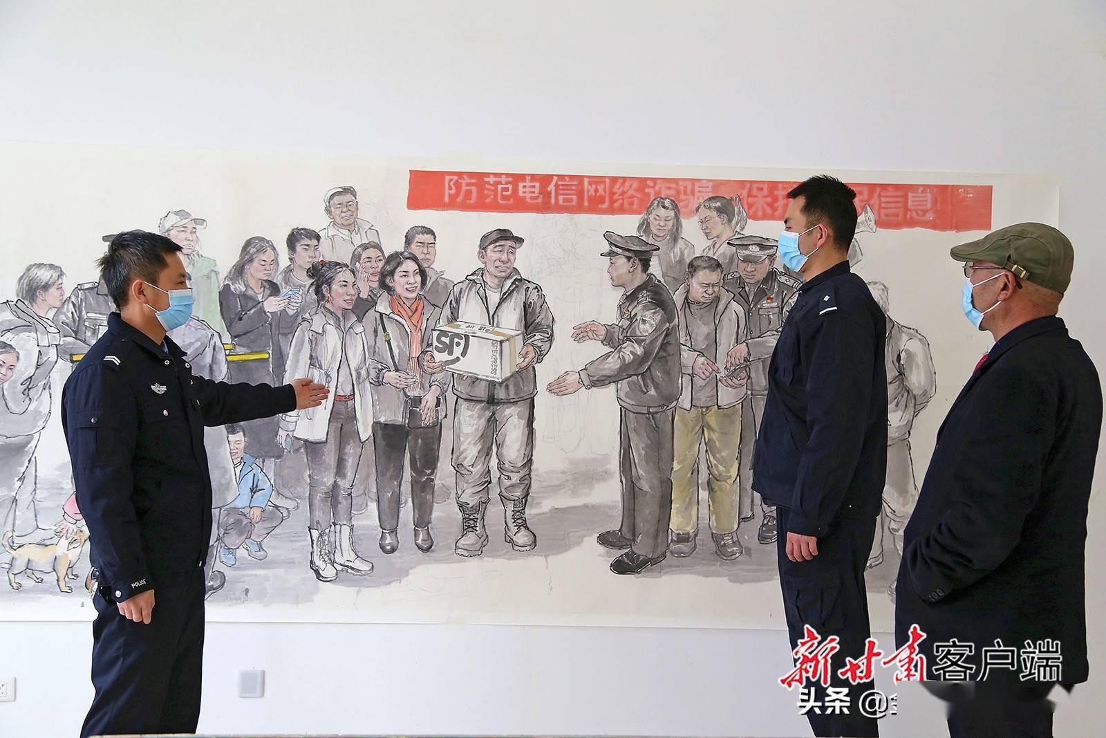 刑侦大队民警兰辉正在展示自己耗时2月绘制成的《防范电信网络诈骗