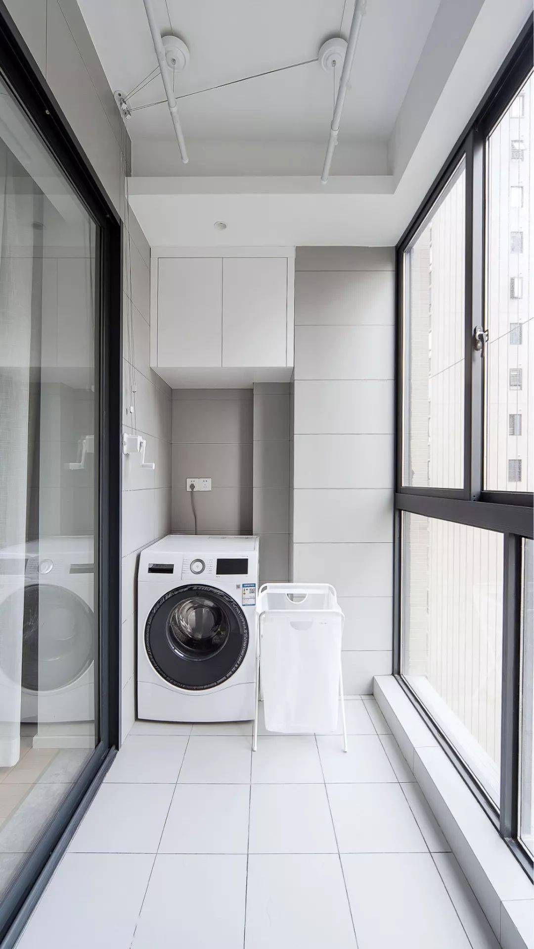 阳台这个空间也没有浪费,洗衣机搭配脏衣篓和晾衣杆,上方角落里做个