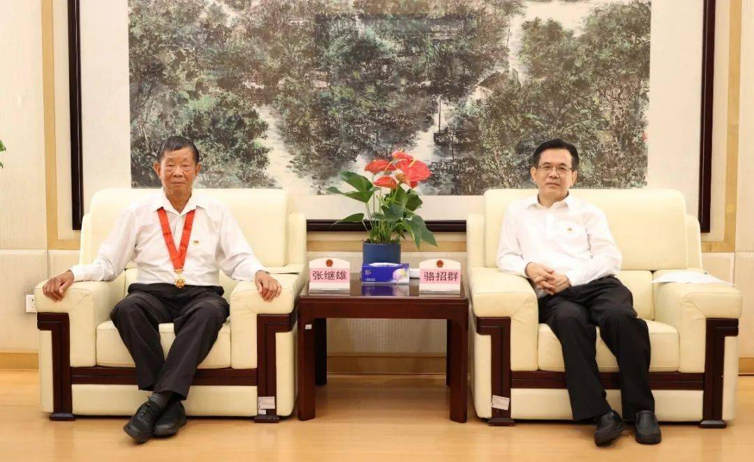 现场,骆招群为张继雄同志颁发"光荣在党50年"纪念章.