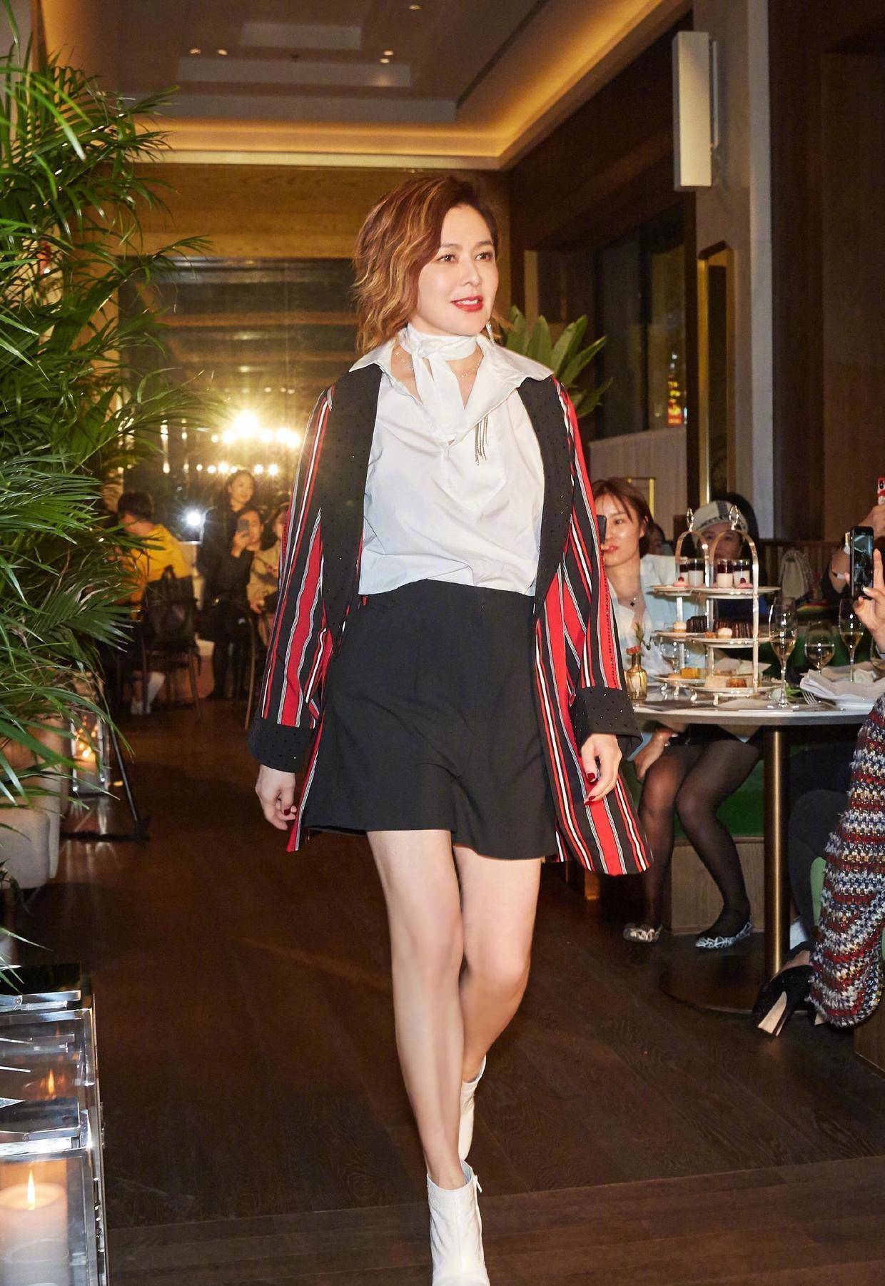 关之琳给这身黑色印花连衣裙配的鞋子也是有小心机的,纯黑色的高跟鞋