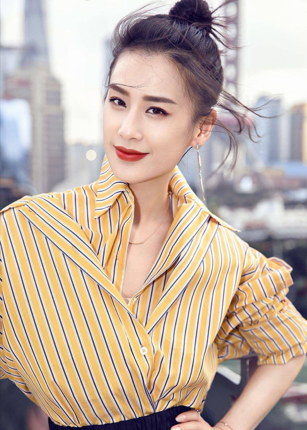 高高扎起丸子头,露出黄圣依精致五官,额前的碎发修饰轮廓线条,平缓