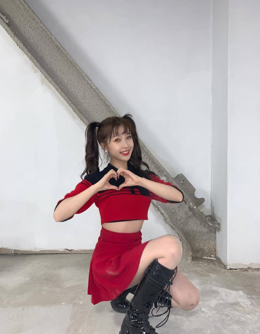 蹲在地上的虞书欣双手比心,显得俏皮又可爱.